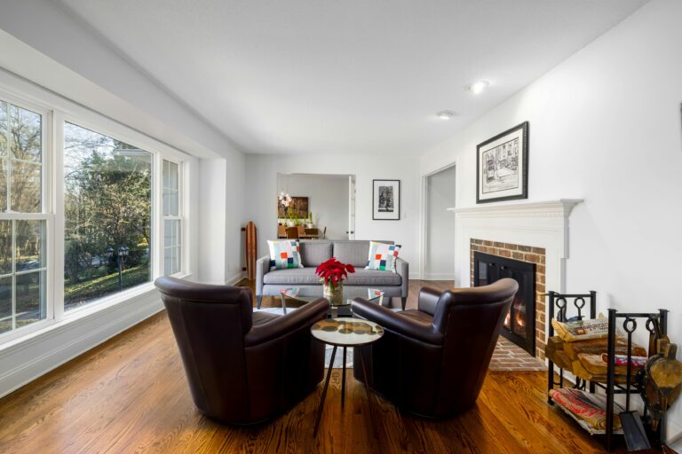 a living room with a fireplace and chairs