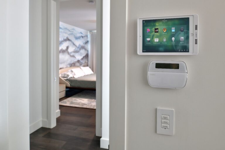 Close up image of Sync Systems installed, wall mounted home automation panel, thermostat and lighting controls.