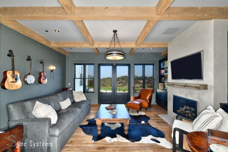 A living room with installed home theater speakers, automated lighting and acoustic treatment.