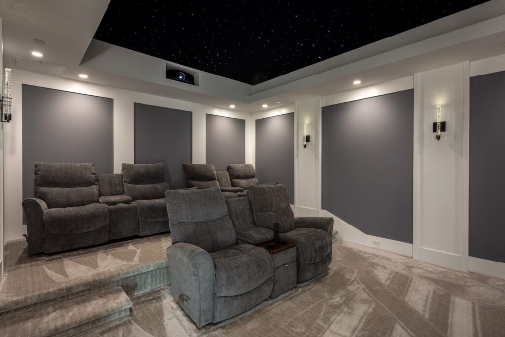 A home theater with large comfy chairs and integrated projector.