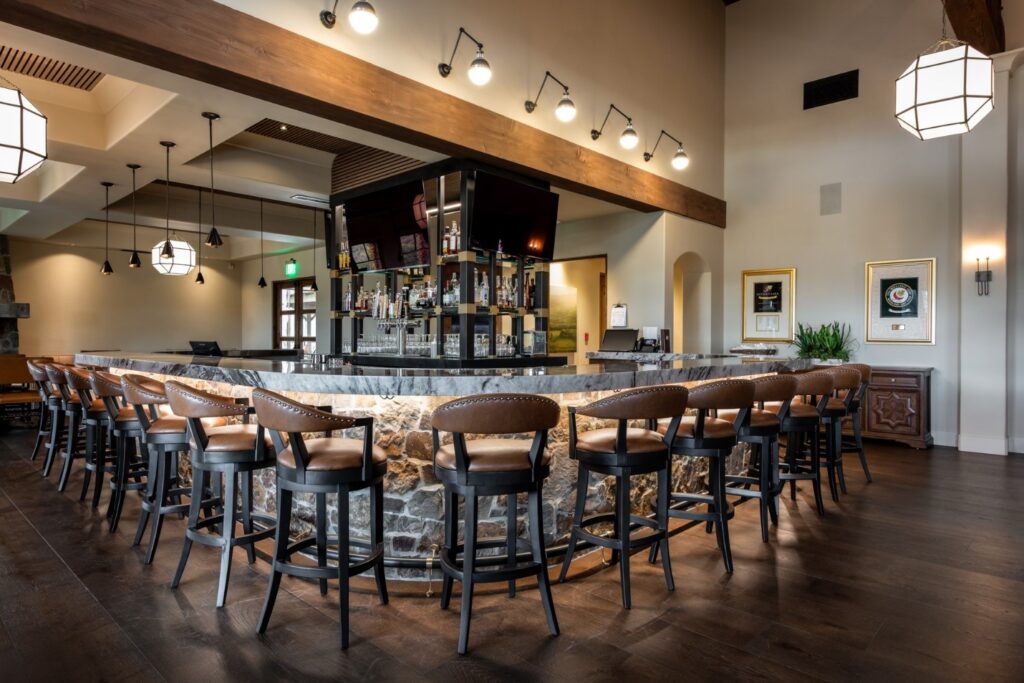 A large bar with multiple TVs in the middle of the bar.