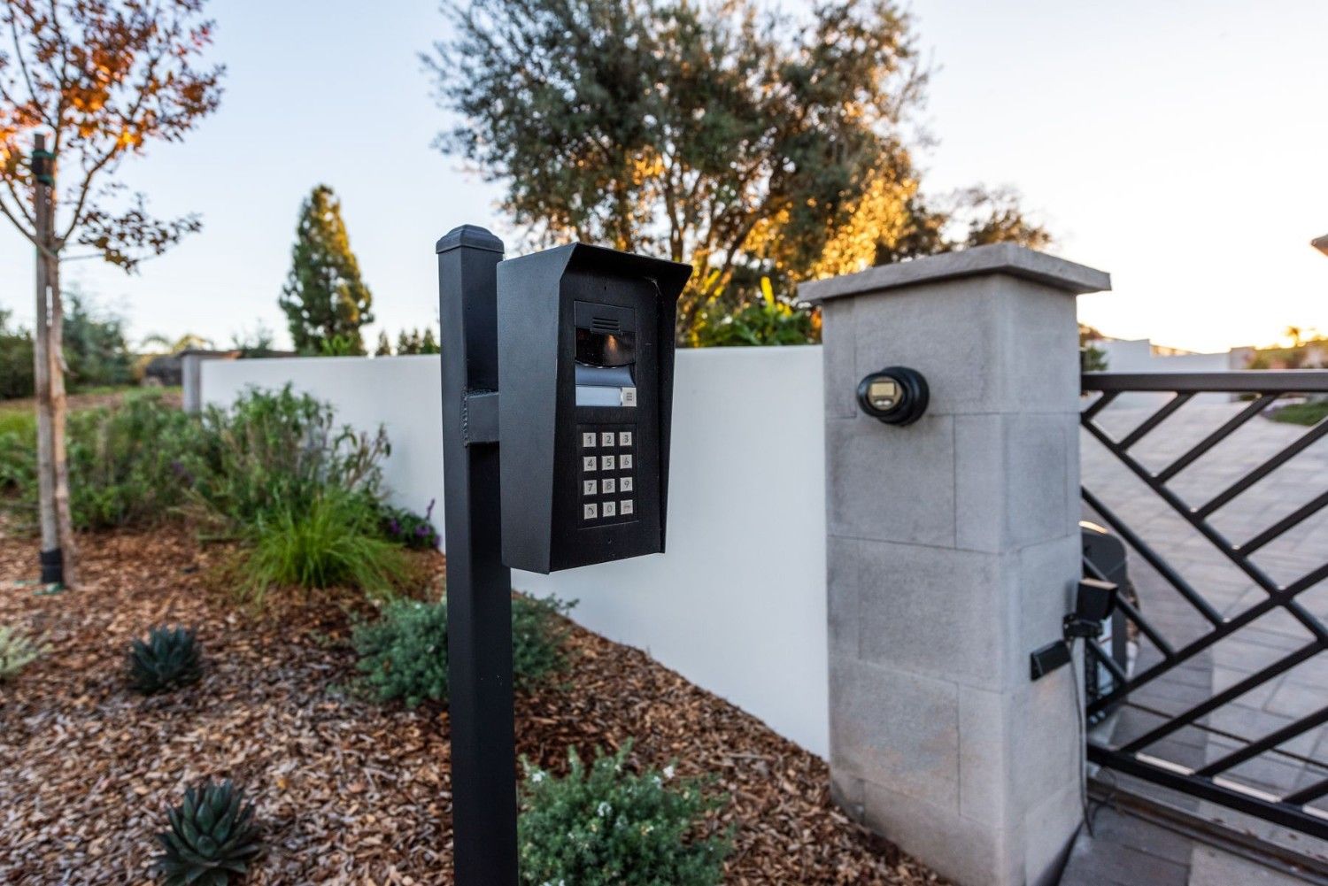 A home gate with security keypad entry lock and cameras.