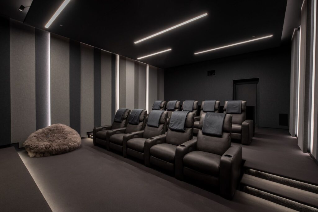 A luxury home theater with leather reclining chairs.