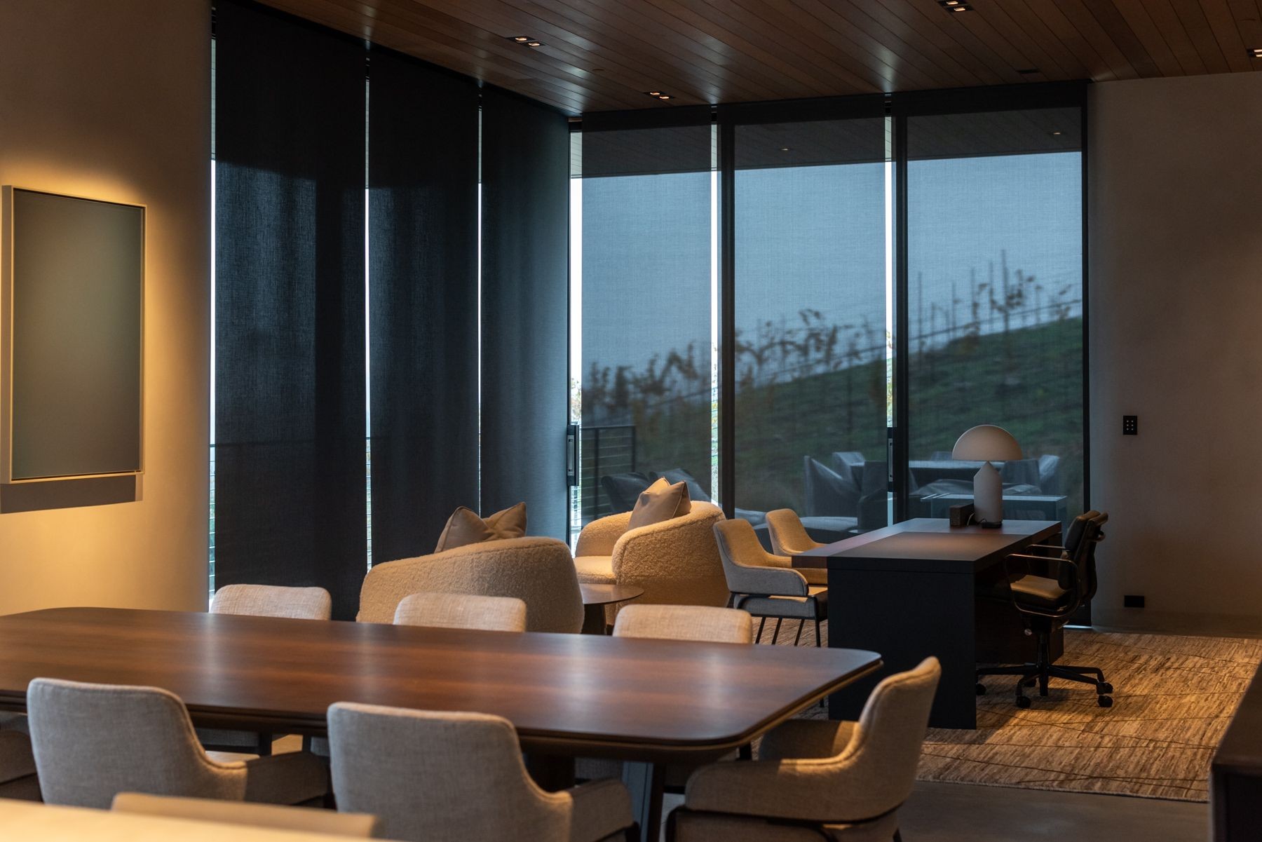 A modern dining room with motorized shades lowered.